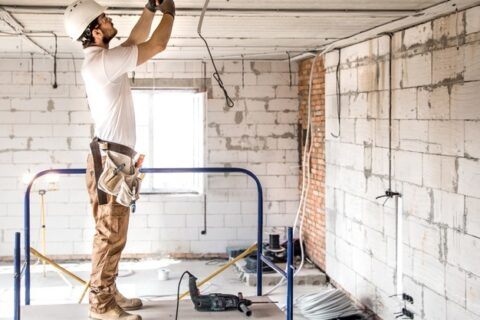 A professional electrician working in a commercial facility