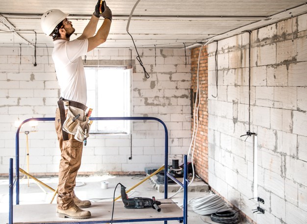 A professional electrician working in a commercial facility