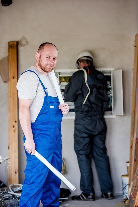 A commercial electrician fixing a business’s lights.